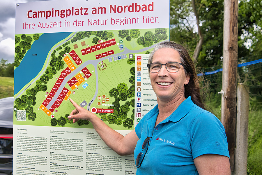 Ulrike Heinicke zeigt auf die Campingplatzstellflächen-Tafel