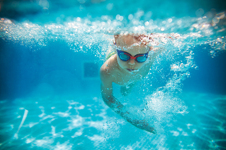 Kind schwimmend im Wasser
