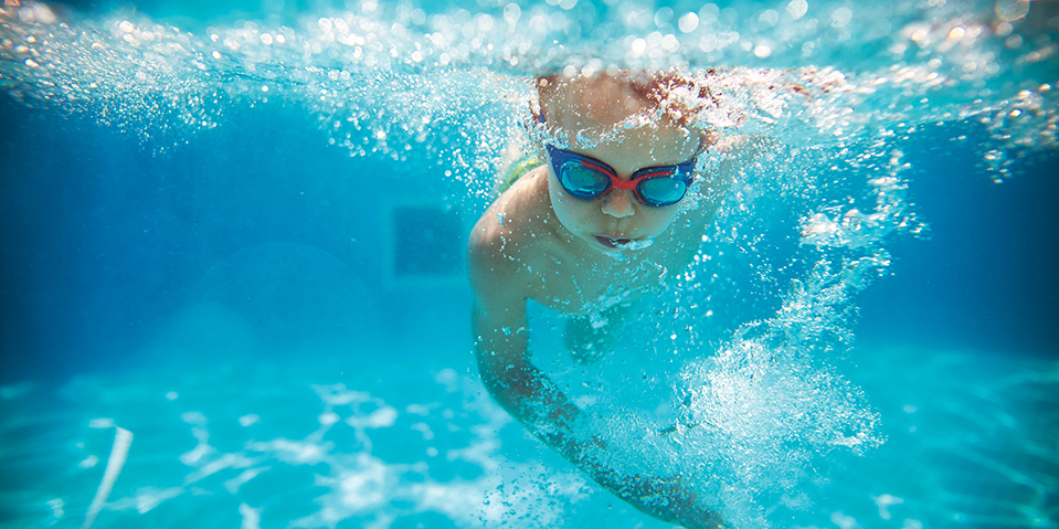 Kind schwimmend im Wasser