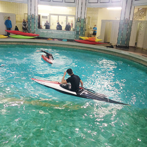 Kanufahrer beim Kenterrollentraining im Schwimmbecken.