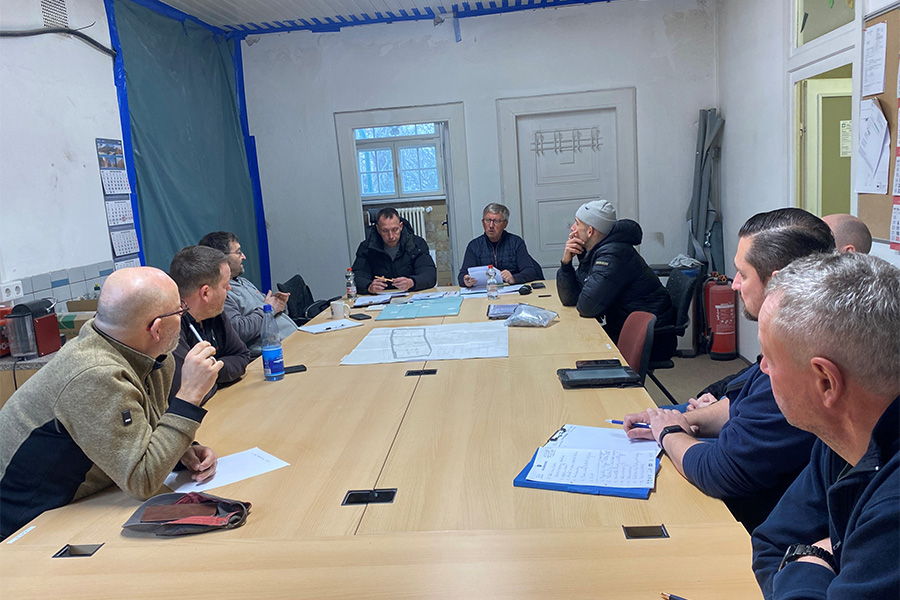 Mitarbeiter sitzen zusammen an einem großen Tisch.