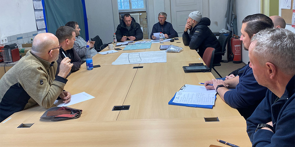 Mitarbeiter sitzen zusammen an einem großen Tisch.