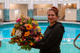 Floristmeisterin Diana Träger hält den Jubiläumsstrauß zu Ehren des Stadtbads Halle.